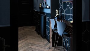 A modern kitchen with a dark color scheme, a wooden herringbone floor, and a dining area with two white chairs. - ART ROOM One of one Experiences (Rome)