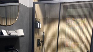 A modern bathroom with a large black sink, a mirror, and a shower enclosure with vertical blinds. - ART ROOM One of one Experiences (Rome)