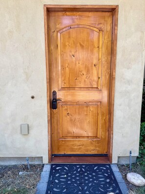 A wooden door with a metal handle and a doormat. - Centrally located, bright studio next to the bike path in downtown Hailey (Hailey)
