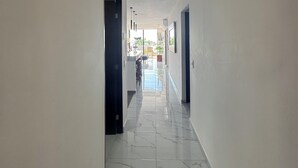 Un passadís amb parets blanques i un paviment de rajoles.