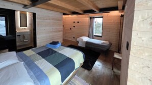 A cozy cabin-style room with a bed, a small desk, and a window. - Muranche loft S1, fined and elegant apartment with Jacuzzi (Pâquier)