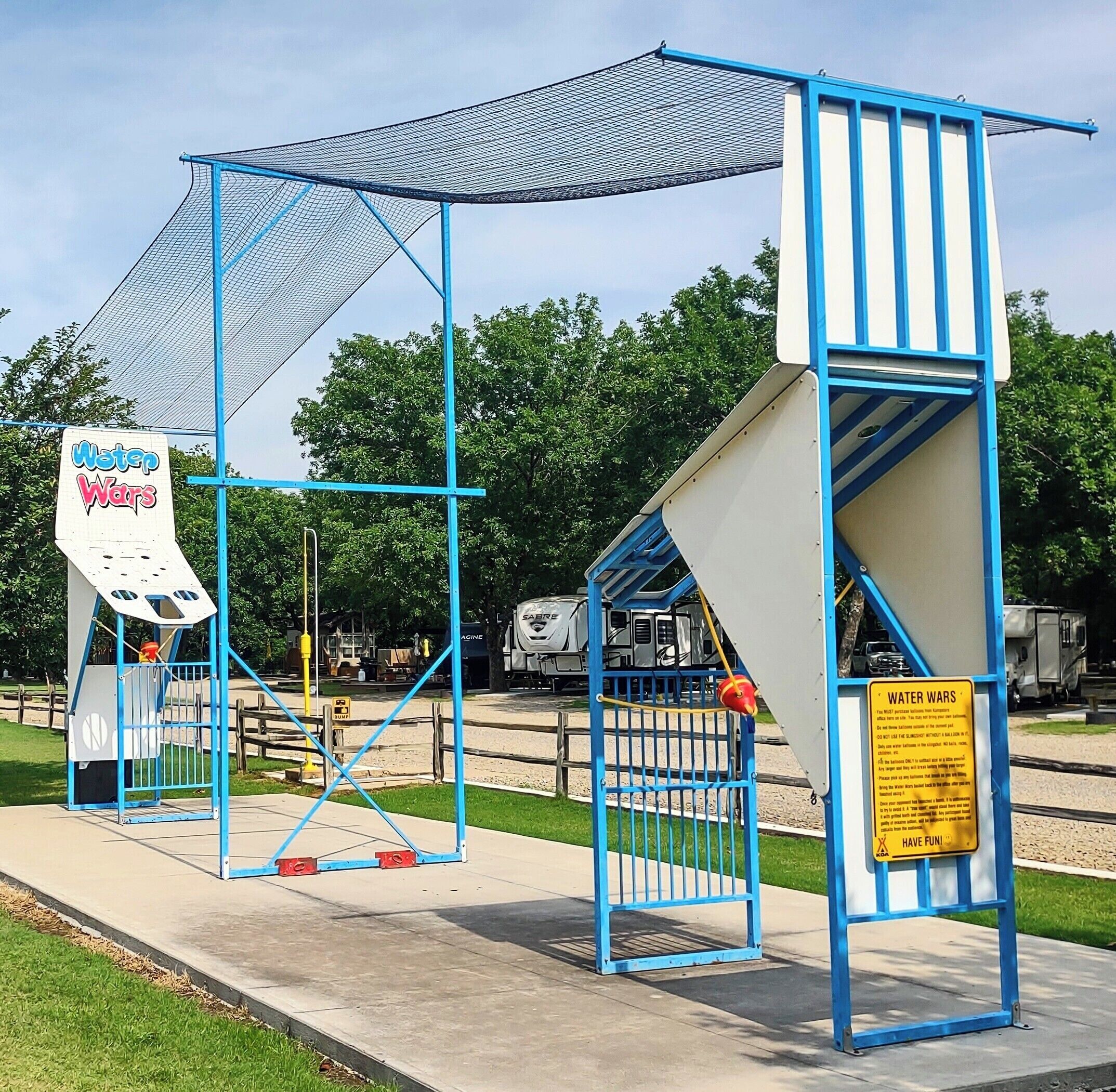 A water play structure named 'Water Wars' with a blue and white color scheme, featuring a slide and a water pump.