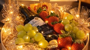 A wooden fruit and wine basket with a label, surrounded by string lights and two framed photos. - House with Private Pool and Gourmet Area (Cascavel)