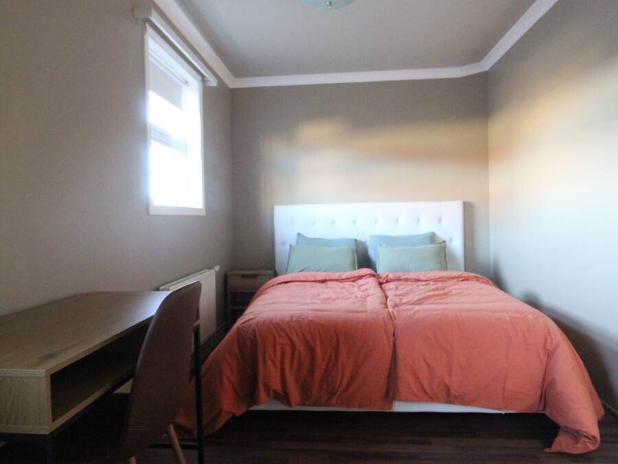 Ein Schlafzimmer mit einem Bett, einem Schreibtisch und einem Stuhl.