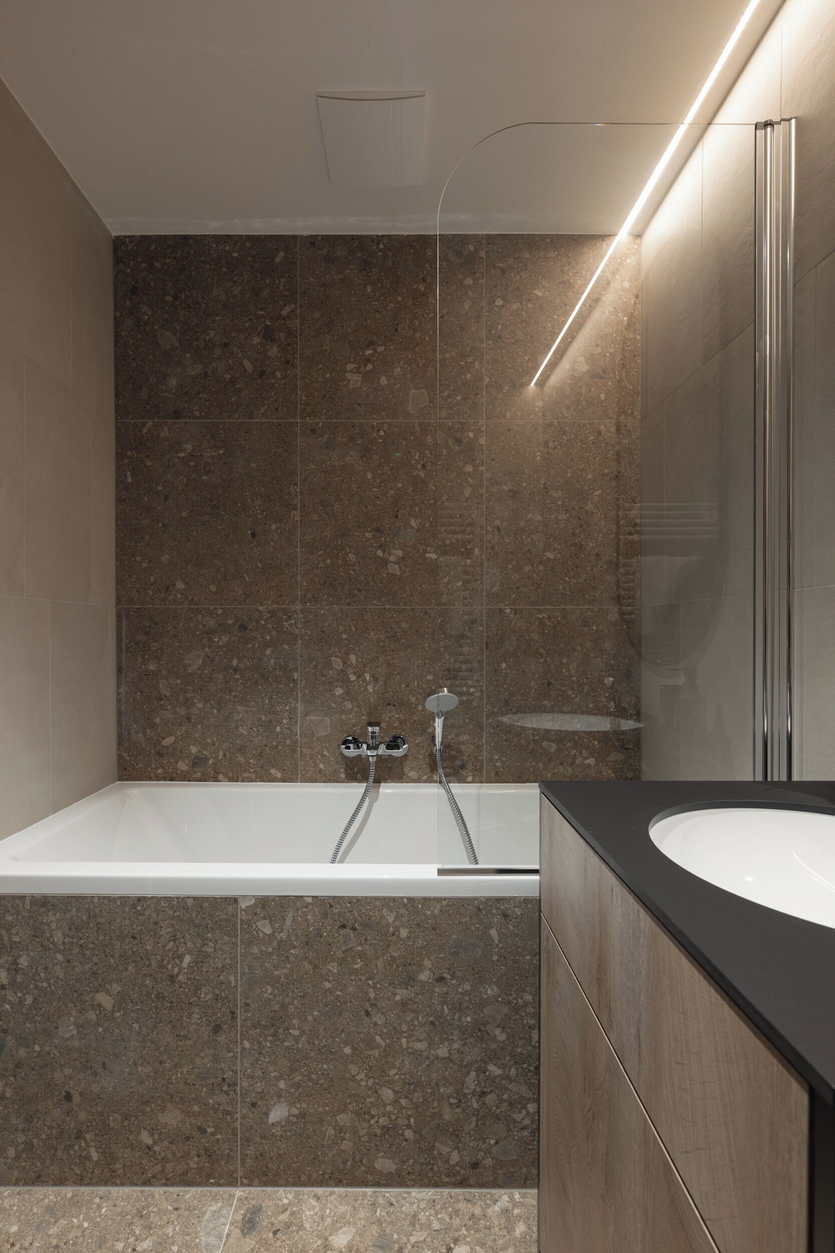 Un baño moderno con una bañera independiente, un espejo grande y una zona de ducha.