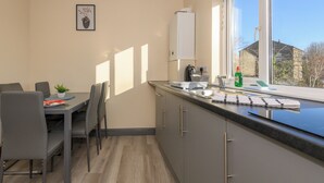 Ett modernt kök med en matplats, ett fönster med utsikt och en liten växt på bordet.