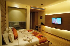 A hotel room with a bed, a TV, and a massage table. - RRV Hotel (Amritsar)