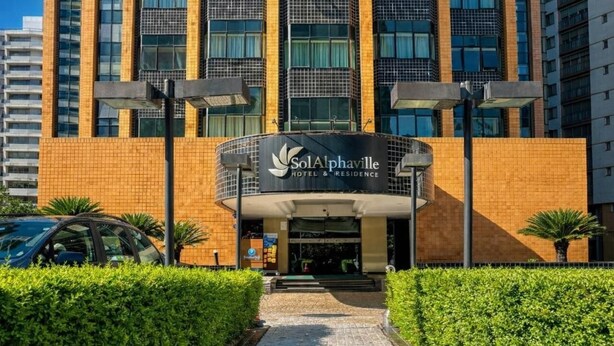 Een hotelentree met een bord waarop staat: SolAlphaville Hotel & Residence.