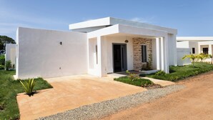 Una casa moderna con fachada blanca, una pared de acento de piedra y un camino de entrada de grava.