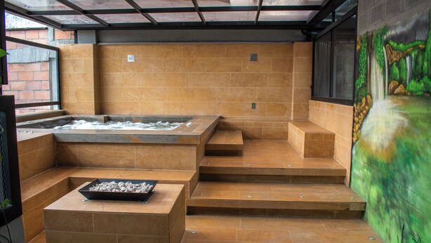 A spa area with a hot tub, a massage table, and a mural on the wall. - Modern 2BR Apartment in Helena ✨ Terrace, Jacuzzi & Café (Medellín)