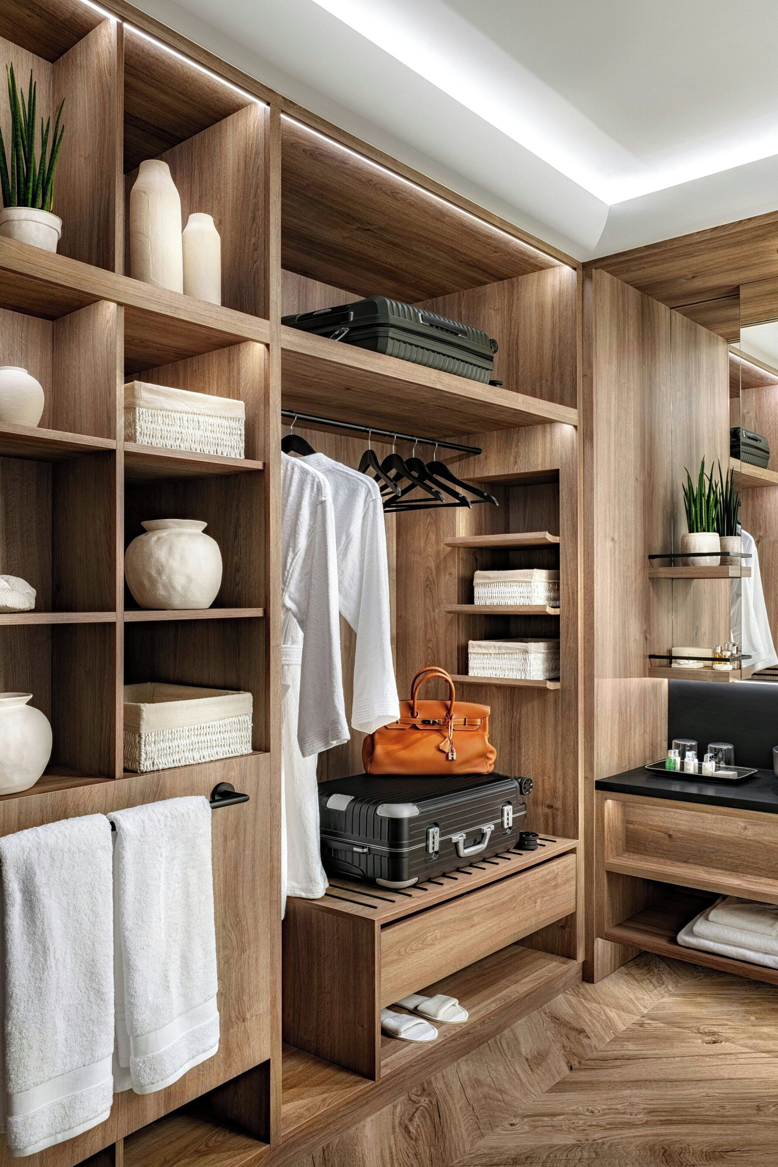 A wooden closet with shelves, a hanging rack, and a bench.