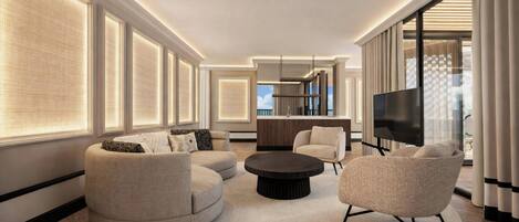 A modern living room with a round coffee table, two sofas, a TV, and a kitchen area in the background.