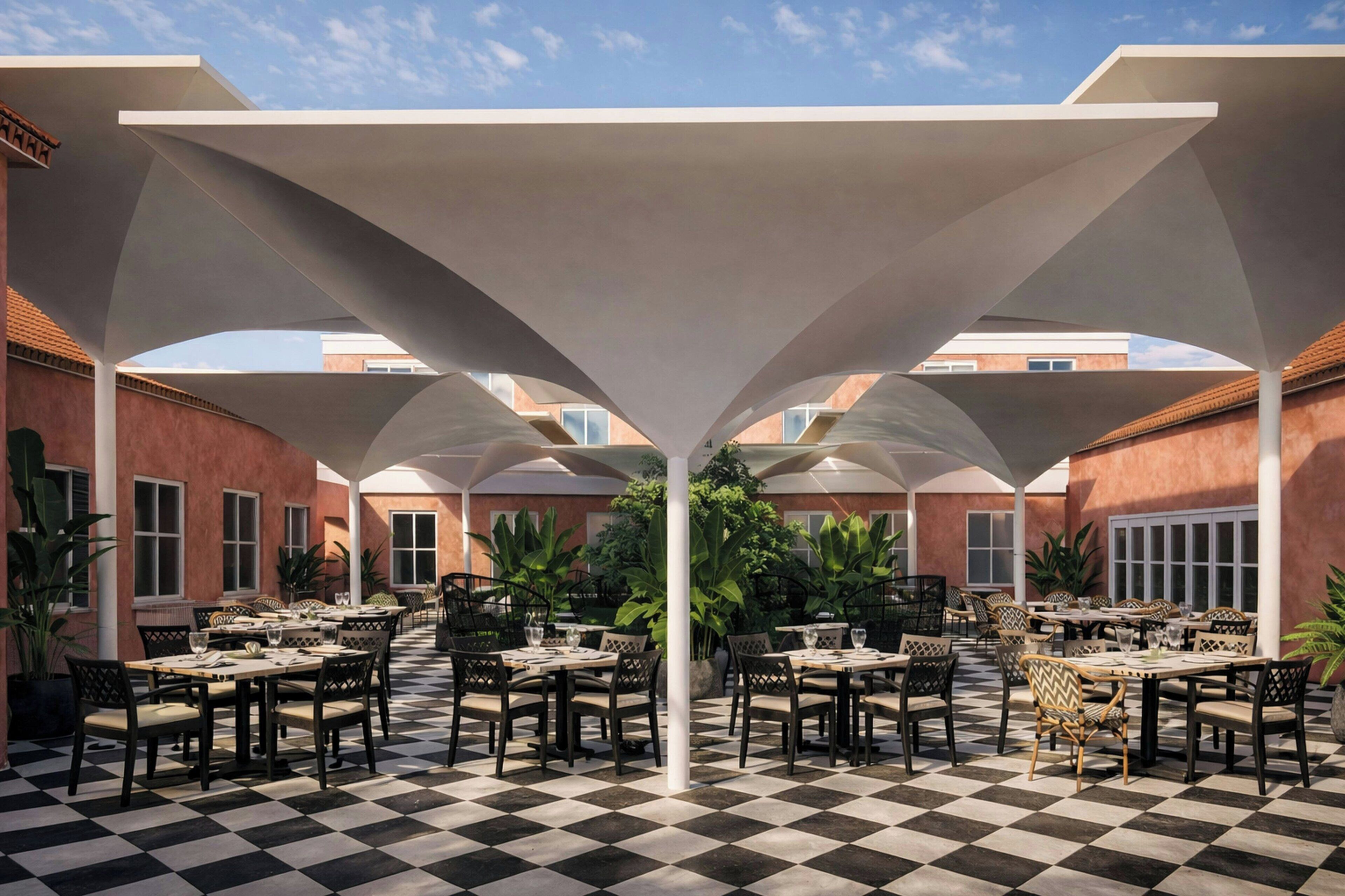 An outdoor dining area with checkered flooring, tables, chairs, and umbrellas.