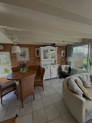 Ein gemütliches Wohnzimmer mit Essbereich, einem weißen Schrank und einer Couch.