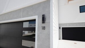 A modern building with a garage door, a number '18' on the wall, and a small window. - NashLo Boji Retreat (Arnolds Park)