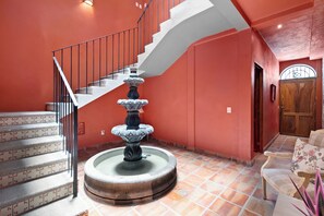 Eine Treppe mit einer Zierbrunnen, einer Holztür und einem gemusterten Boden.