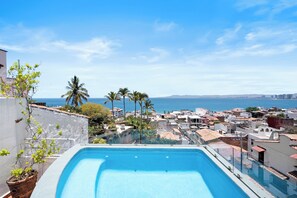 A rooftop pool with a view of the ocean and cityscape. - 3BR Private Retreat with Rooftop Pool, Steps to Malecon & Zona Romantica (Puerto Vallarta)