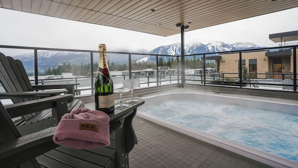 A rooftop terrace with a hot tub, seating area, and a bottle of champagne. - Monashee Meadows (Revelstoke)
