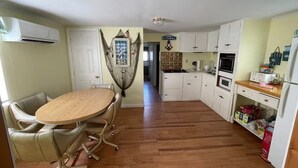 Una cocina con una mesa de comedor, sillas y un adorno colgante.
