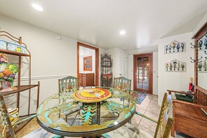 Un espace repas comprenant une table ronde en verre, des chaises et un élément décoratif central.