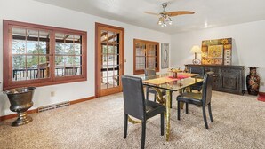 A dining area with a glass table, four chairs, a ceiling fan, and a decorative cabinet. - Twin Fawns - EV #3417 (Estes Park)