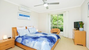 A bedroom with a bed, nightstands, a TV, a chair, and a window with curtains. - 2 Marto Court, Normanville (Normanville)