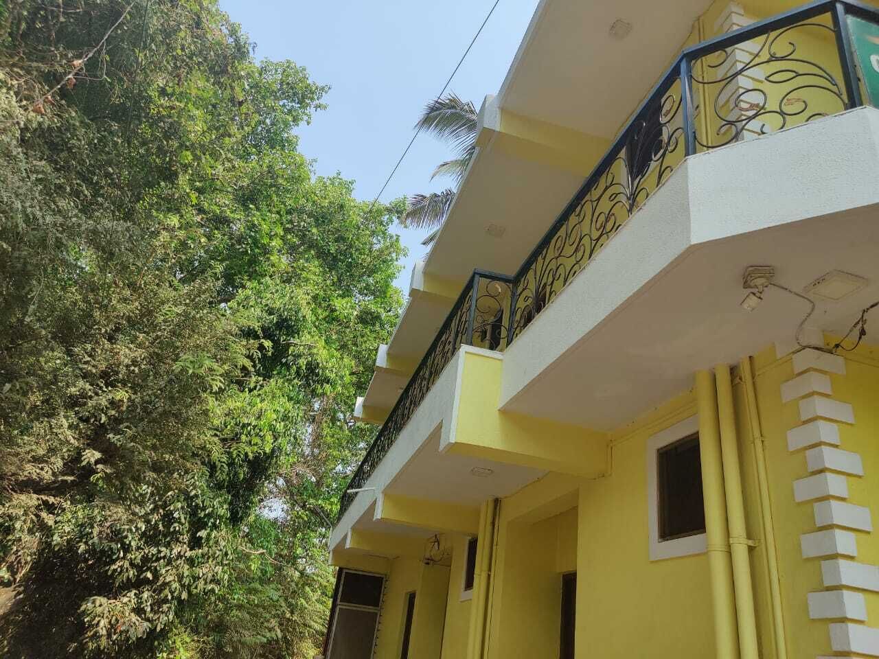 A yellow building with a balcony and a window.