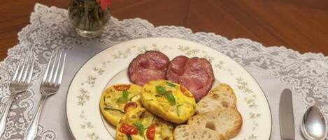 A plate with eggs, bacon, and toast on a lace tablecloth.