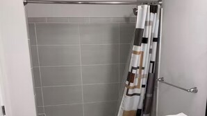 Une salle de bain moderne équipée d’une douche, de toilettes et d’un lavabo.