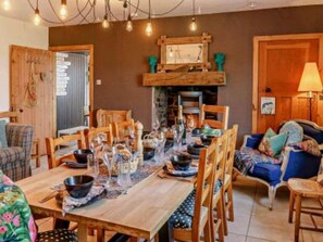 Un comedor con una mesa de madera dispuesta para una comida, rodeada de sillas.