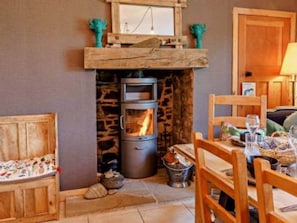 Una habitación acogedora con chimenea de piedra, muebles de madera y una mesa de comedor preparada para una comida.