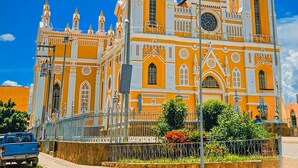 A large, ornate church with multiple towers and a prominent clock. - Apartment next to the Basilica of Saint Francis, Downtown Canindé, Ceará (Canindé)