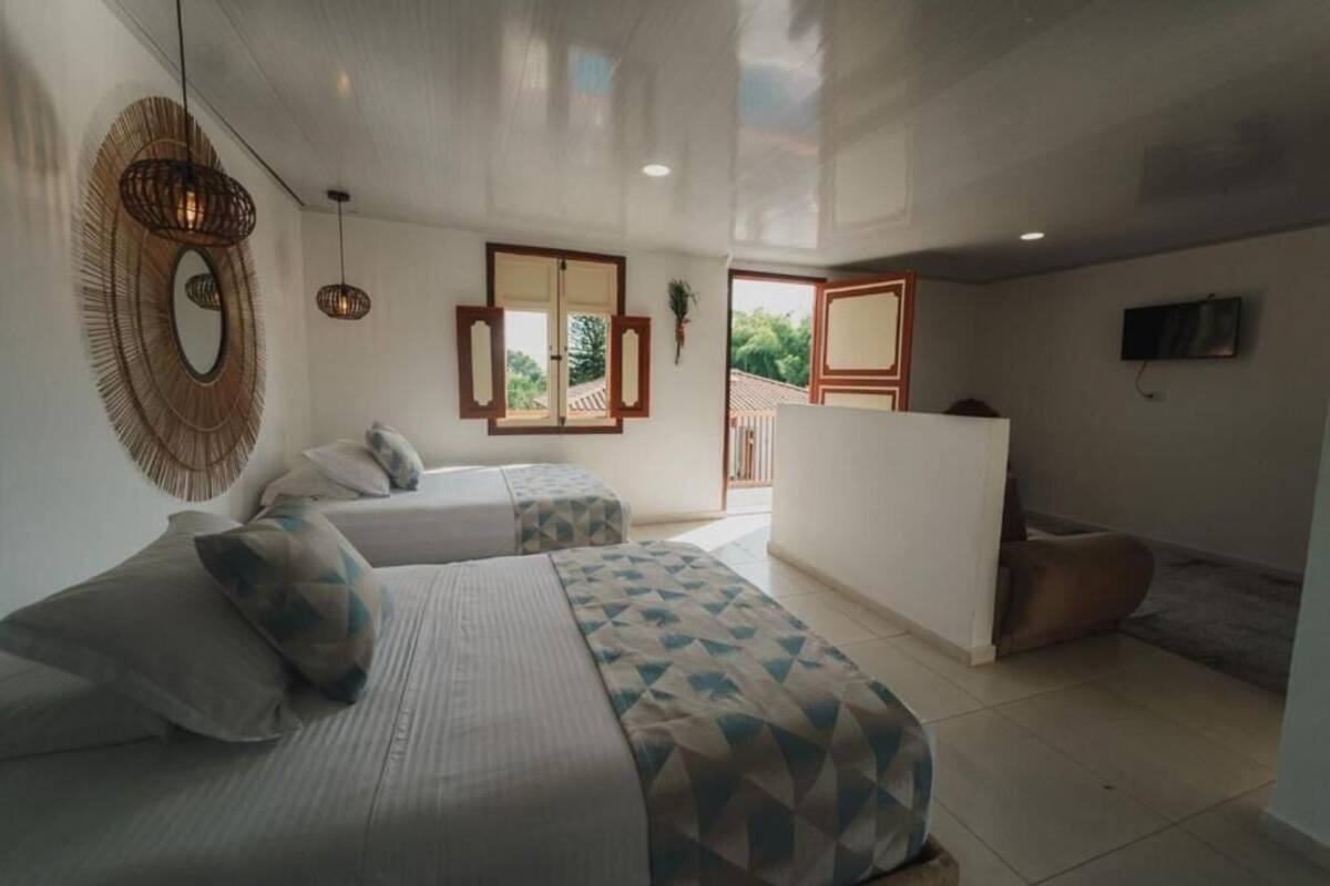 Une chambre moderne avec deux lits, un grand miroir et un téléviseur.