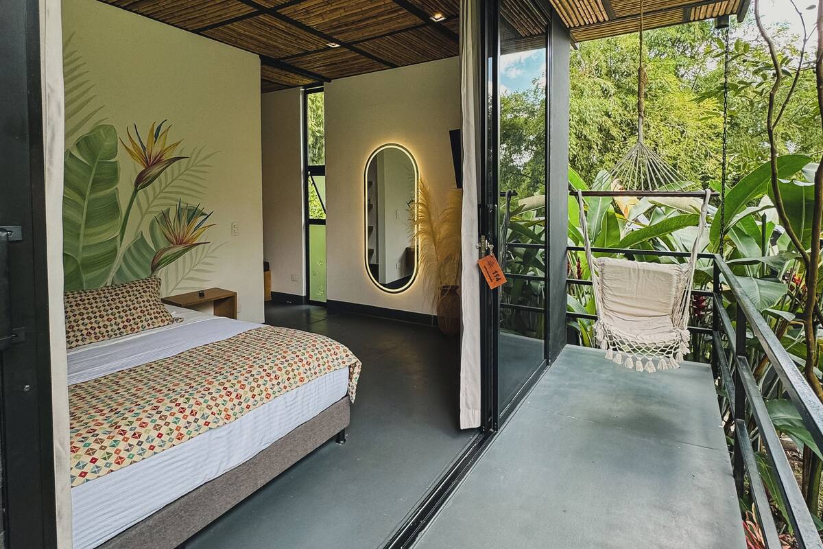 Une chambre à coucher moderne avec un lit, un grand miroir et un hamac.