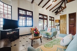 A living room with a television, sofa, and coffee table. - Casa Blue Wind • Private Home with Pool & A/C near Manuel Antonio Beaches (Quepos)