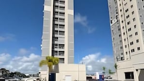 Ein modernes Hochhaus mit einem Schwimmbecken im Vordergrund.