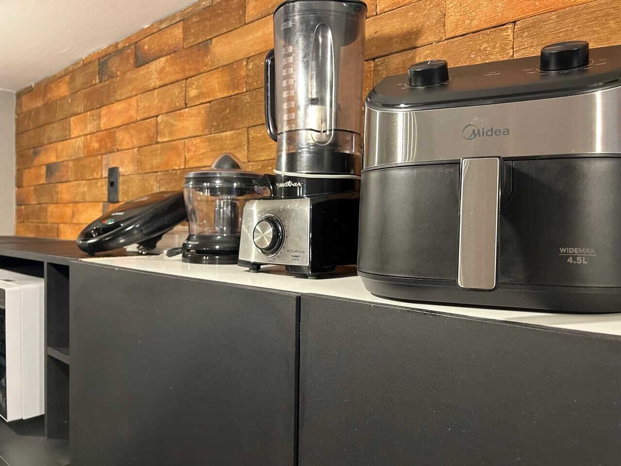 A kitchen with a blender, a coffee maker, and a rice cooker on a countertop.