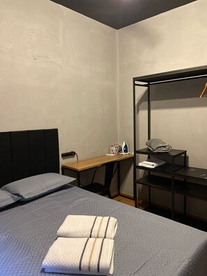 A compact hotel room with a bed, a desk, and a wardrobe. - 1003 Apto 2 Qtos João Pessoa Cabedelo (Cabedelo)