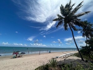 A beach with a clear sky, palm trees, and a sandy shore. - 1003 Apto 2 Qtos João Pessoa Cabedelo (Cabedelo)