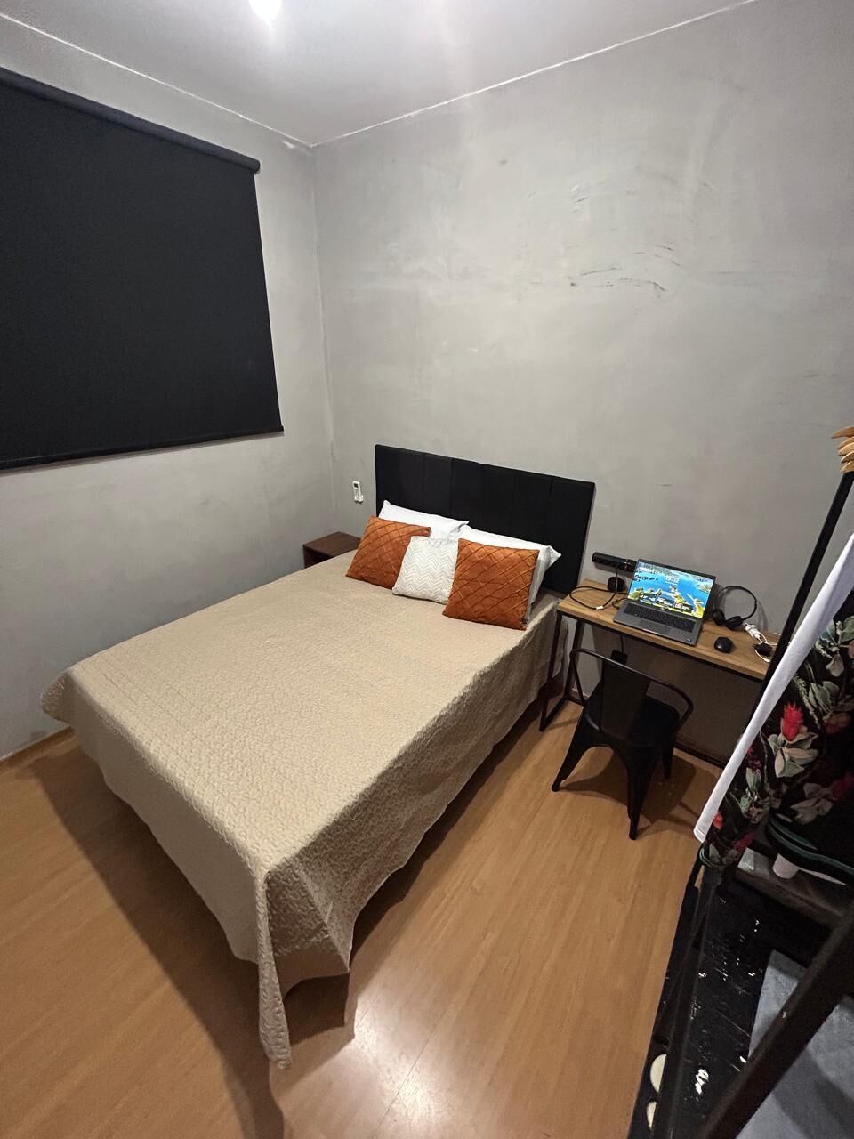 A bedroom with a bed, a desk, and a chair.