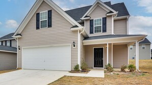 A two-story house with a garage, a covered front porch, and a small front yard. - 4 Mi to Hospital & Dtwn Greensboro: Spacious Home (Greensboro)