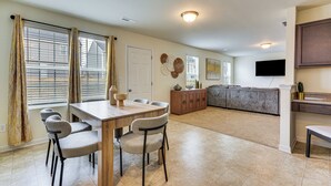A spacious living area with a dining table, chairs, a sofa, and a TV mounted on the wall. - 4 Mi to Hospital & Dtwn Greensboro: Spacious Home (Greensboro)