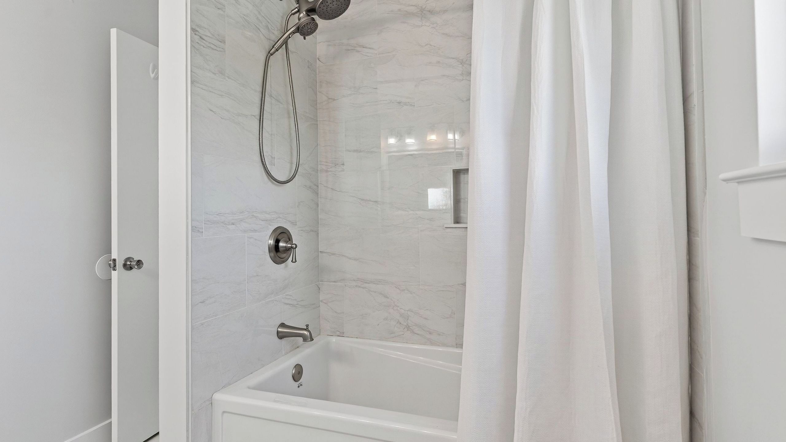 Un baño con bañera, ducha y puerta.