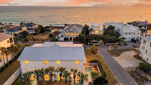 Um bairro residencial com casas, uma piscina e vista para o oceano.