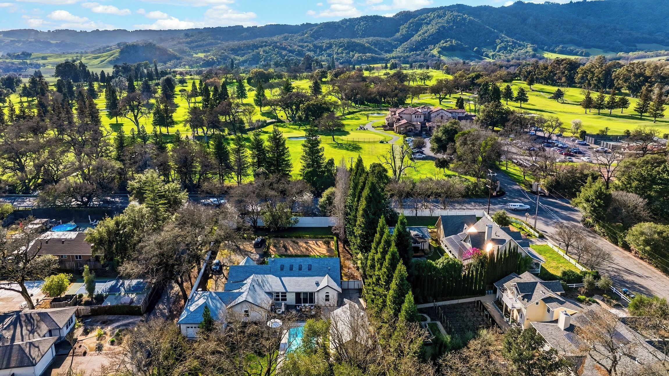 Una zona residenziale con case, una piscina e un campo da golf.