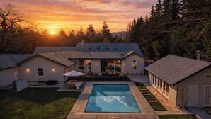 Una propiedad residencial con piscina, zona de patio y una casa con garaje.