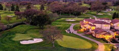 A golf course with a clubhouse featuring multiple buildings and a well-maintained landscape.