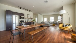 Un vaste espace de vie comprenant une table à manger en bois, un canapé et un fauteuil jaune.