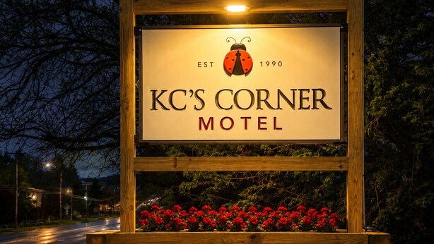 KC's Corner -motellin puinen kyltti, jossa on logo, perustamisvuosi ja nimi.