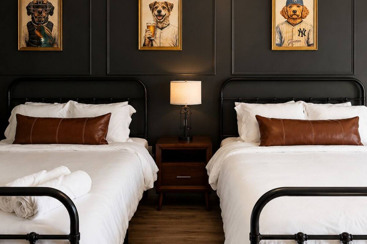 Una habitación de hotel con dos camas, una mesita de noche, una lámpara y decoración en las paredes.